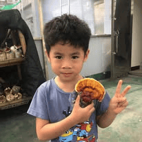 孩子手捧自己照顧長大的靈芝,開心地比出手勢,記錄雅歌私塾養菇與生命觀察的學習歷程。